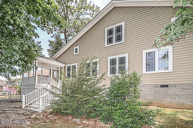 exterior space with a sunroom, stairway, crawl space, a gate, and fence