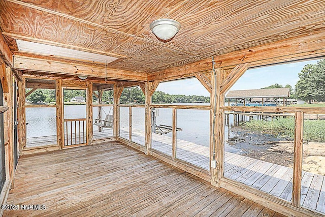 unfurnished sunroom featuring wood ceiling and a water view