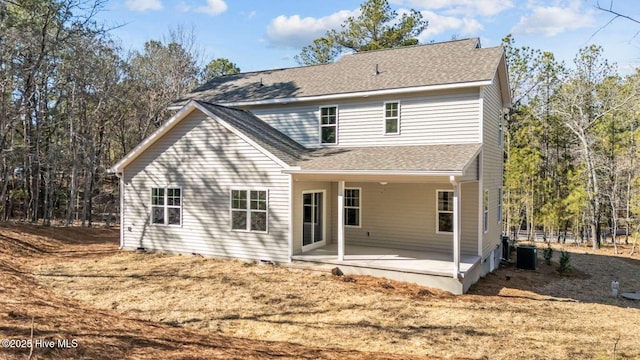 back of property with roof with shingles, cooling unit, and a patio