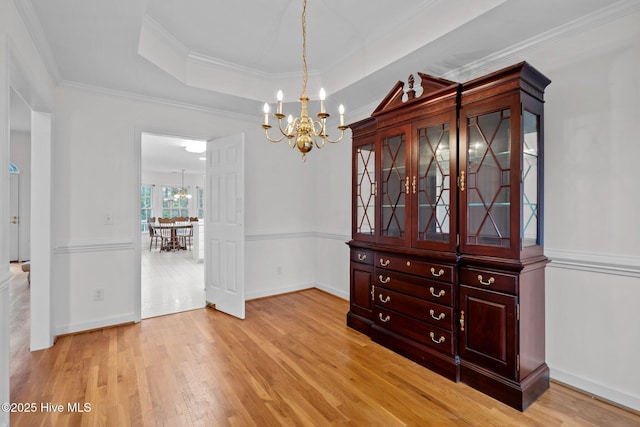 126 Francis Marion Dr, Wilmington, NC 28411 - unfurnished dining area featuring crown molding, light wood-type flooring, a raised ceiling, and a notable chandelier