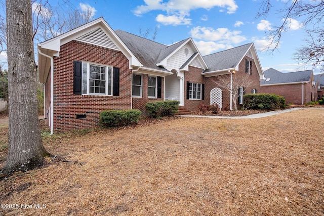 view of front of property with brick siding, crawl space, and a shingled roof