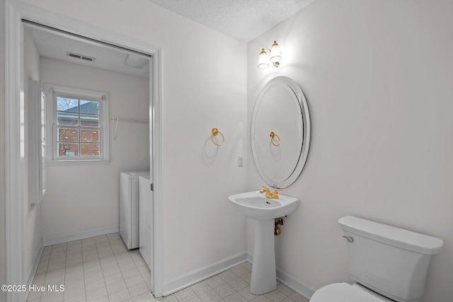 126 Francis Marion Dr, Wilmington, NC 28411 - bathroom with baseboards, visible vents, toilet, a textured ceiling, and separate washer and dryer