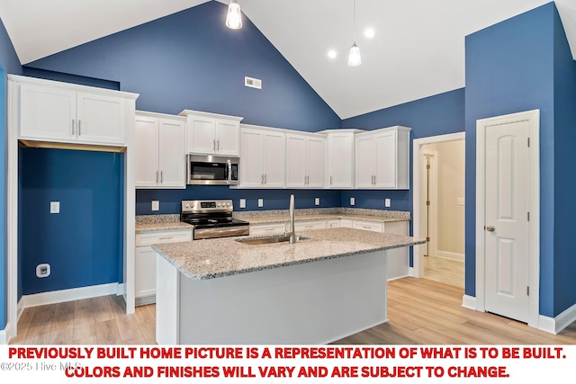 kitchen featuring light wood finished floors, appliances with stainless steel finishes, white cabinets, high vaulted ceiling, and a sink