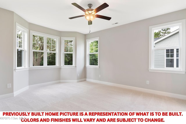 carpeted spare room featuring baseboards, visible vents, and ceiling fan