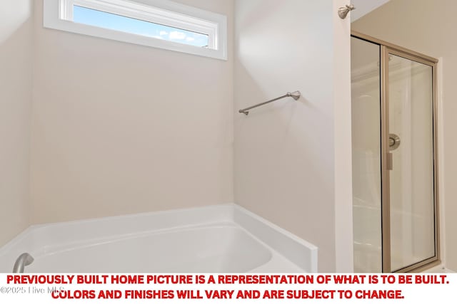 full bathroom featuring a shower stall and a garden tub