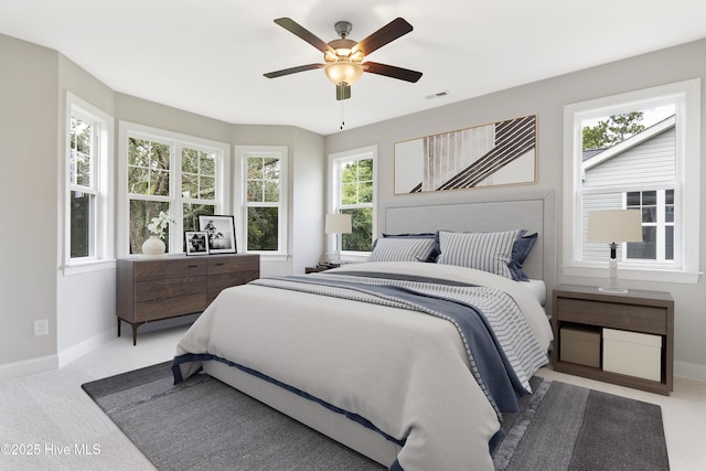 carpeted bedroom featuring visible vents, ceiling fan, and baseboards