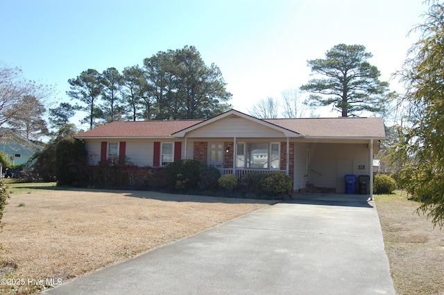 single story home featuring a porch, a front yard, concrete driveway, and brick siding