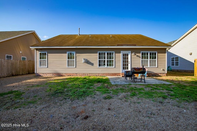 back of property with a yard, a patio area, and fence