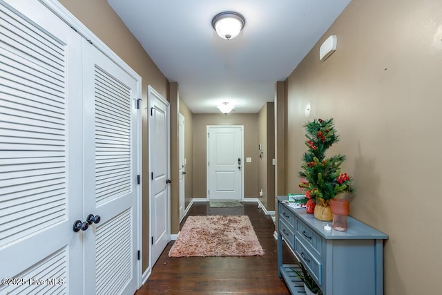 doorway to outside featuring dark wood-style flooring and baseboards