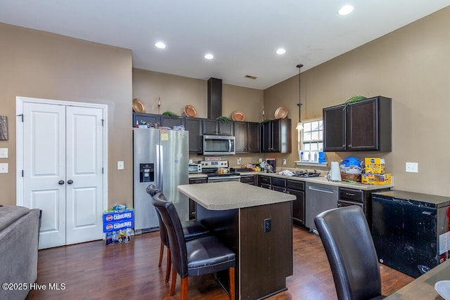 kitchen featuring stainless steel appliances, light countertops, dark wood finished floors, and a center island