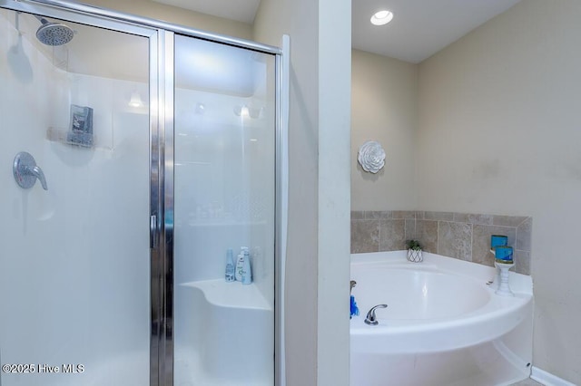 full bath featuring a stall shower and a garden tub