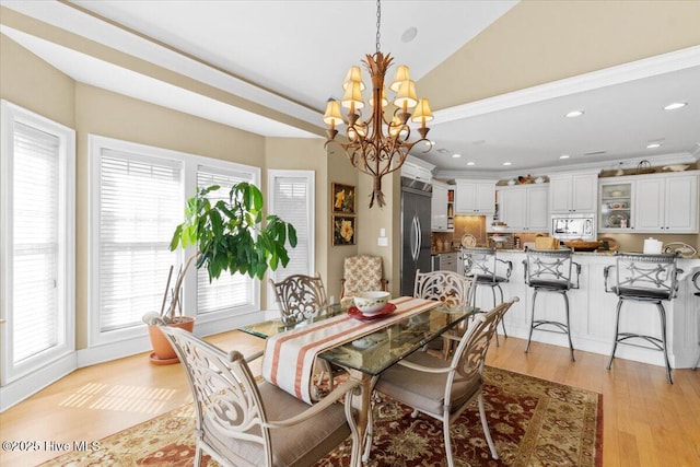 dining area with recessed lighting, a wealth of natural light, an inviting chandelier, and light wood-style floors