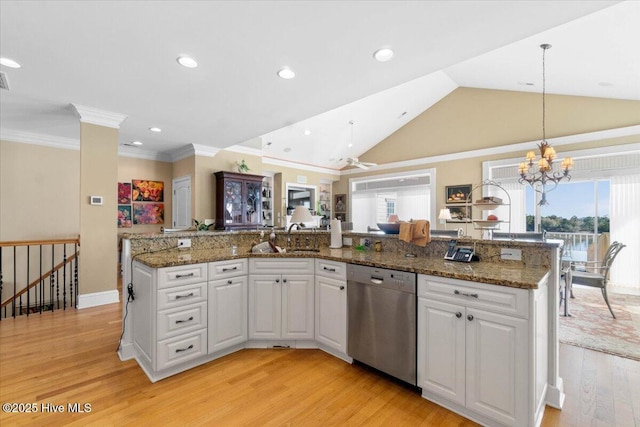 kitchen with plenty of natural light, light wood finished floors, stainless steel dishwasher, a sink, and a chandelier