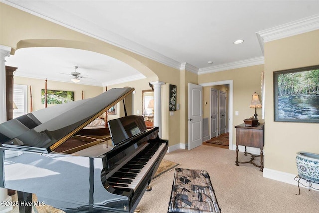 sitting room featuring baseboards, arched walkways, and ornate columns