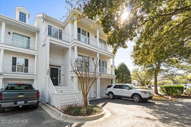 view of front of home featuring aphalt driveway, a balcony, and a garage