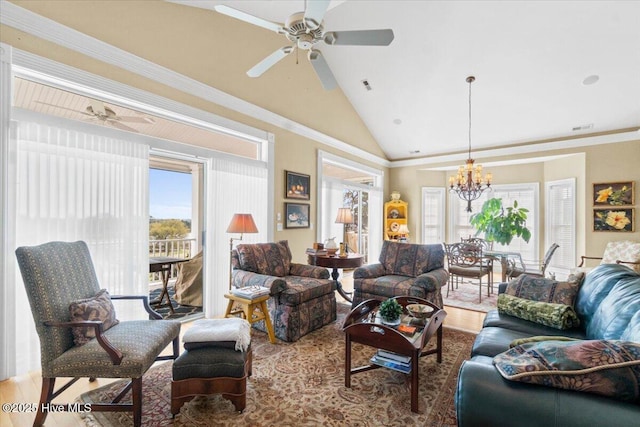 living area featuring vaulted ceiling, a healthy amount of sunlight, and ceiling fan with notable chandelier