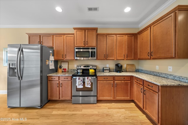 kitchen with ornamental molding, appliances with stainless steel finishes, visible vents, and brown cabinets