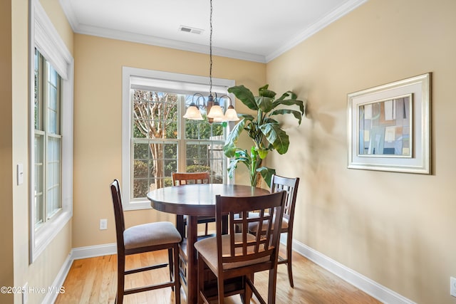 dining space featuring light wood-style floors, visible vents, ornamental molding, and baseboards