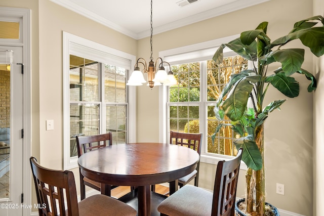 dining room featuring a notable chandelier, visible vents, and crown molding