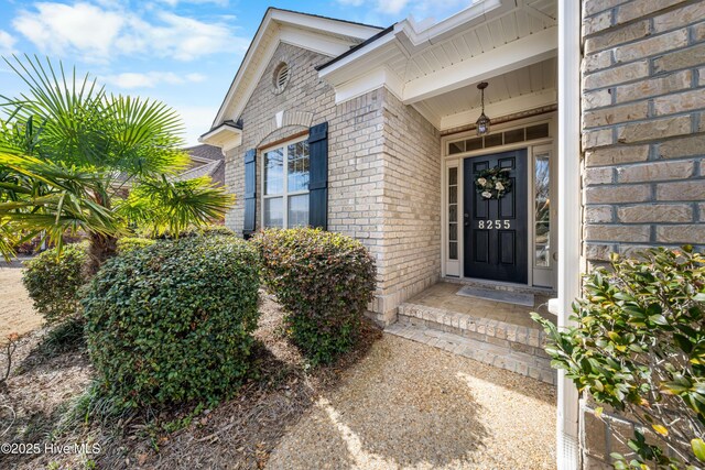 entrance to property featuring brick siding