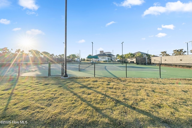 view of sport court with a yard and fence