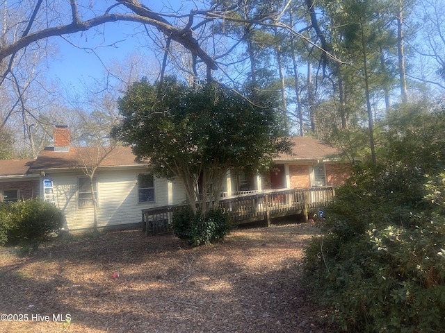 view of side of home with a chimney and brick siding