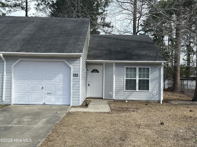 view of front of house featuring a shingled roof, concrete driveway, and a garage