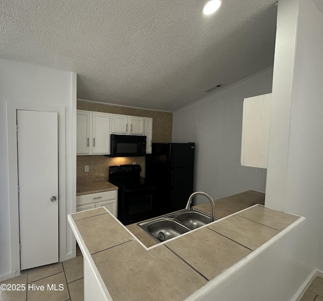 kitchen with light tile patterned floors, visible vents, white cabinets, black appliances, and a sink