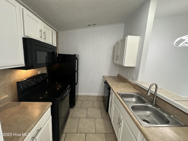 kitchen with light tile patterned floors, a sink, visible vents, white cabinetry, and black appliances