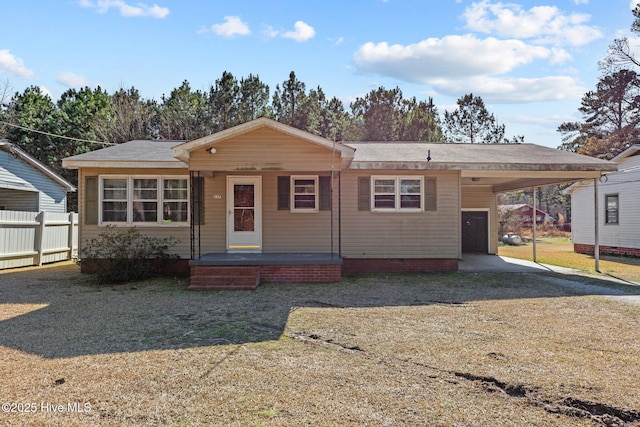 view of front facade with driveway, fence, a front lawn, and a carport