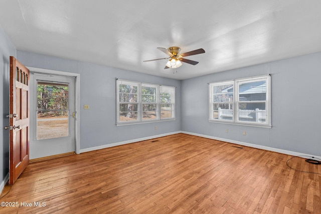 empty room featuring light wood-style flooring, baseboards, and ceiling fan