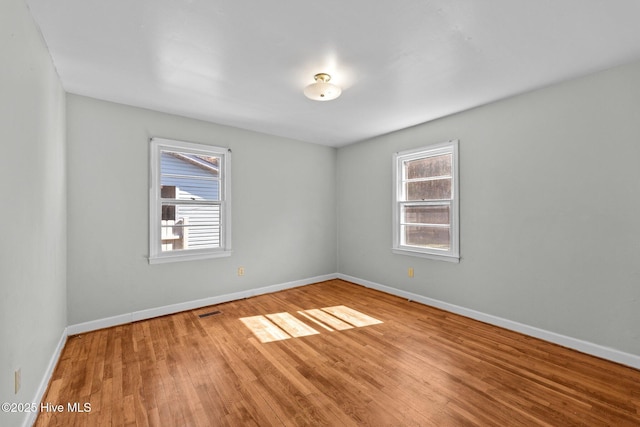 unfurnished room with plenty of natural light, visible vents, and baseboards