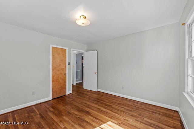 interior space with wood finished floors, visible vents, and baseboards