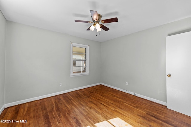 empty room featuring ceiling fan, baseboards, and wood finished floors