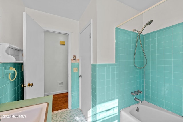 full bathroom featuring a wainscoted wall,  shower combination, and tile walls