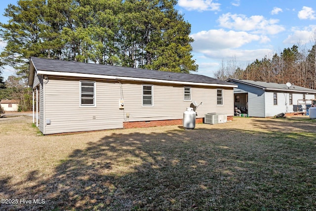 back of property featuring a yard, crawl space, and central air condition unit