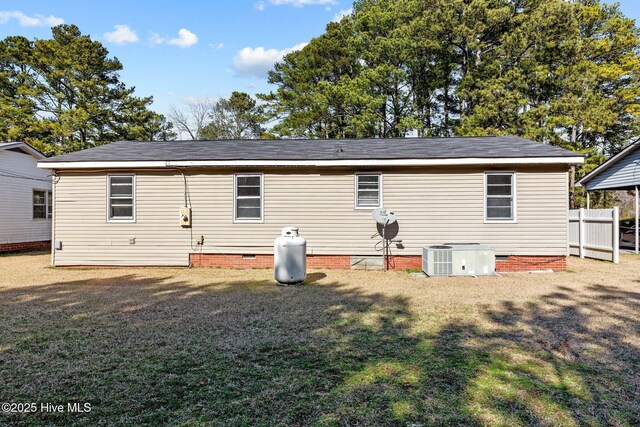 rear view of house with central AC unit, crawl space, fence, and a lawn