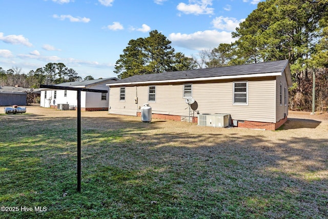 rear view of property featuring central air condition unit, crawl space, and a yard