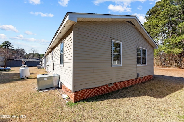 view of side of property featuring crawl space, central air condition unit, and a lawn