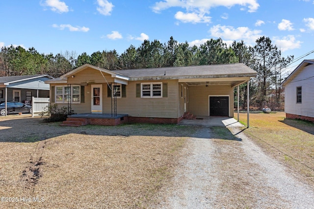 view of front of house with driveway, covered porch, a carport, and crawl space