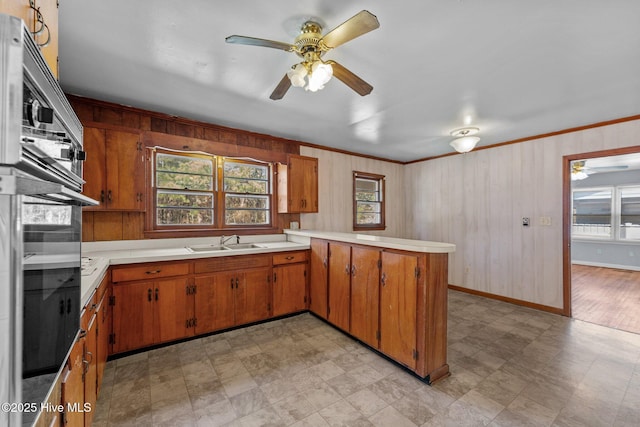 kitchen with plenty of natural light, light countertops, a sink, and oven