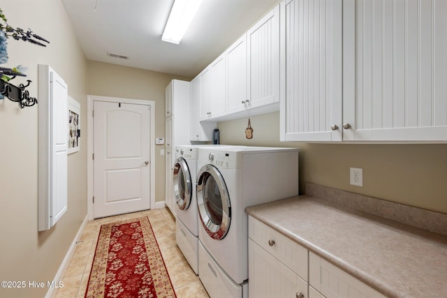 washroom with visible vents, independent washer and dryer, cabinet space, light tile patterned flooring, and baseboards