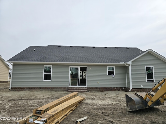 back of house with entry steps and roof with shingles