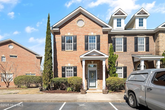 townhome / multi-family property with uncovered parking and brick siding