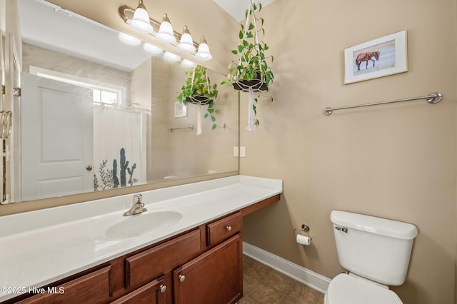 bathroom featuring baseboards, toilet, a shower with curtain, tile patterned floors, and vanity