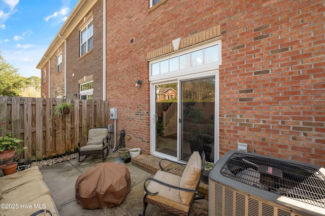 view of patio with central AC unit and fence