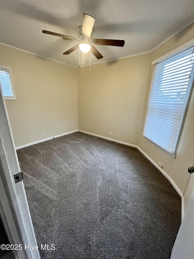 unfurnished room featuring ornamental molding, dark carpet, and baseboards