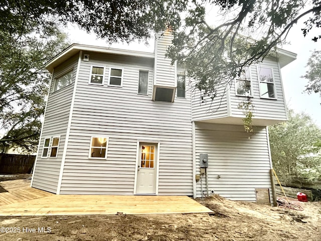 back of house featuring fence, a chimney, and a wooden deck