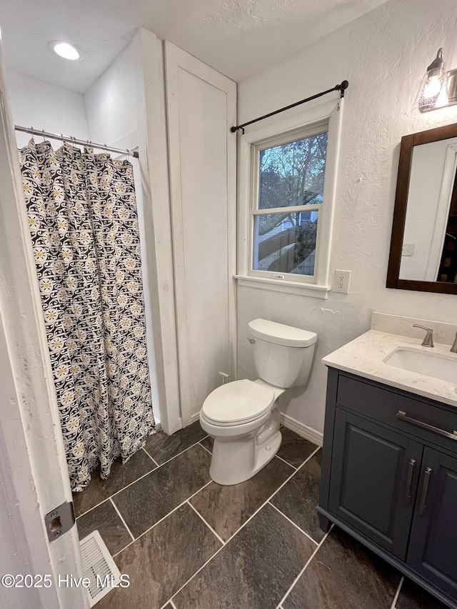 full bath with a textured wall, toilet, vanity, a textured ceiling, and a shower with curtain