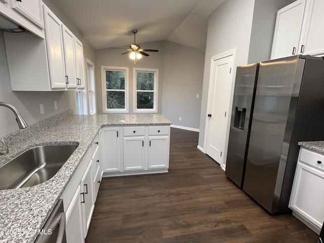 kitchen featuring white cabinets, dark wood-style floors, vaulted ceiling, stainless steel appliances, and a sink